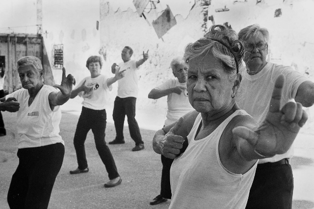 Black and white image of a group of older Cubans taking an exercise class.